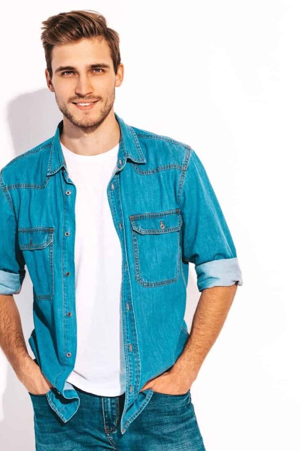 Portrait of handsome smiling stylish hipster lumbersexual businessman model dressed in jeans clothes. Fashion man isolated on white