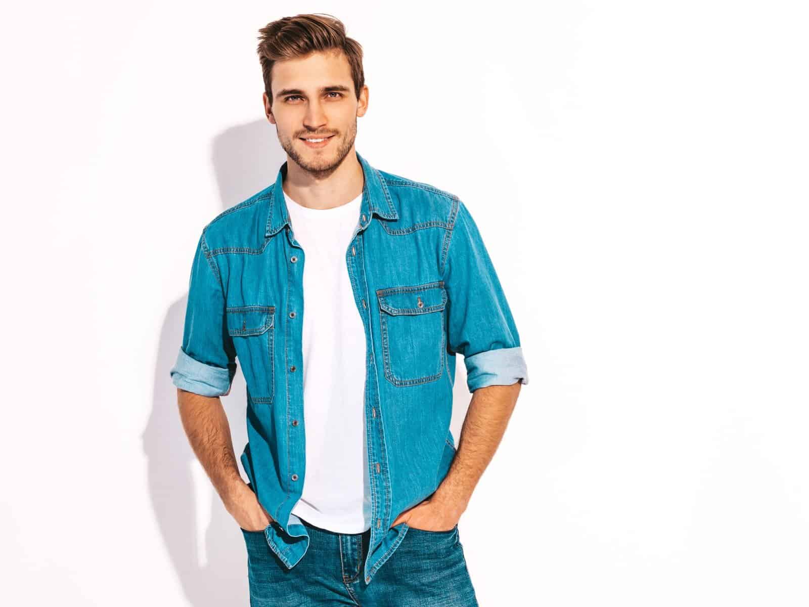 Portrait of handsome smiling stylish hipster lumbersexual businessman model dressed in jeans clothes. Fashion man isolated on white
