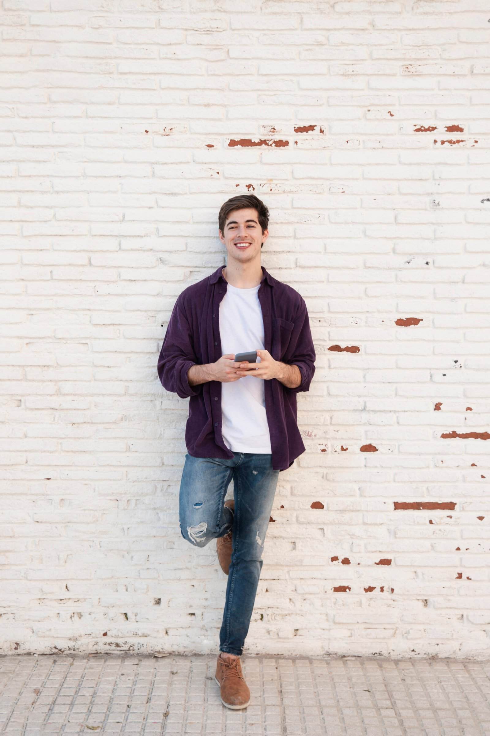 smiley-man-posing-while-holding-smartphone